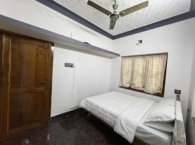 a bedroom with a bed and a ceiling fan at Sreekrishnapuram Family Retreat in Karimpuzha
