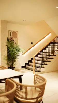 a dining room with stairs and tables and chairs at Aura Inn & Suites in Mysore