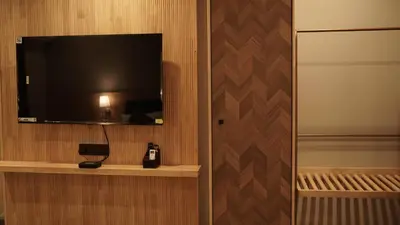 a room with a flat screen tv on a wall at Aura Inn & Suites in Mysore