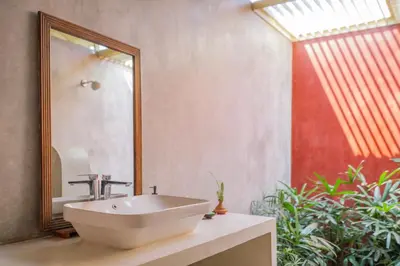 a bathroom with a sink and a mirror at SaffronStays Chandra Amara in Bengaluru