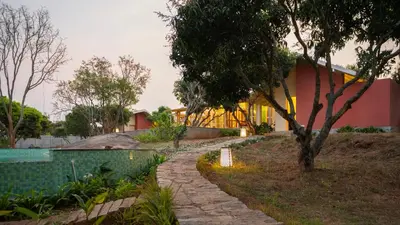 a house with a stone path leading to a building at SaffronStays Chandra Amara in Bengaluru