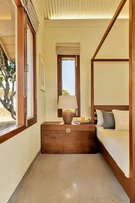 a bedroom with a bed and a window at SaffronStays Chandra Amara in Bengaluru