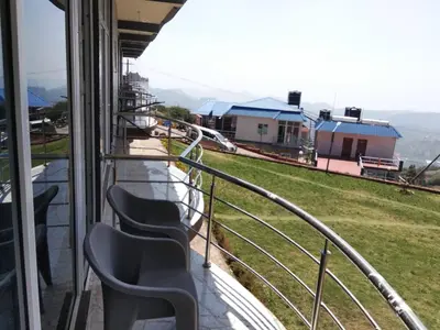 a group of chairs sitting on top of a balcony at TULIPS VILLAGE RESORTS - A Valley View Abode in Ooty