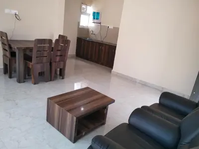 a living room with a couch and a table and chairs at TULIPS VILLAGE RESORTS - A Valley View Abode in Ooty