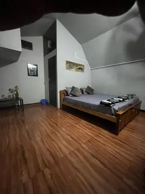 a bed in a room with a wooden floor at spiritofthewild in Attappādi