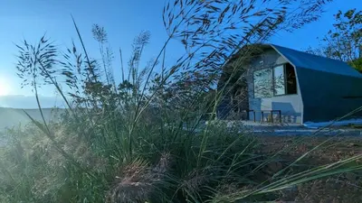 a blue tent sitting on the side of a field at spiritofthewild in Attappādi