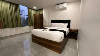 a bedroom with a bed and a large window at Ellora grand hotel in Kozhikode