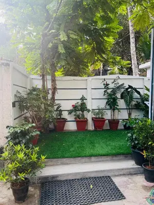 a white fence with potted plants on a lawn at Nandbhavan Guruvayur in Guruvāyūr