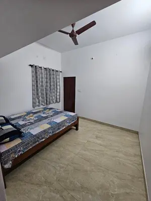a bedroom with a bed and a ceiling fan at Home in Pollachi in Pollāchi