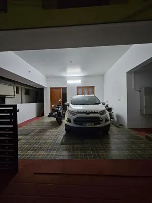 a car parked in a garage with a motorcycle at Home in Pollachi in Pollāchi