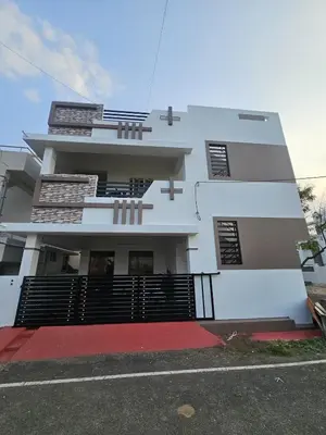 a large white building with a red driveway at Home in Pollachi in Pollāchi