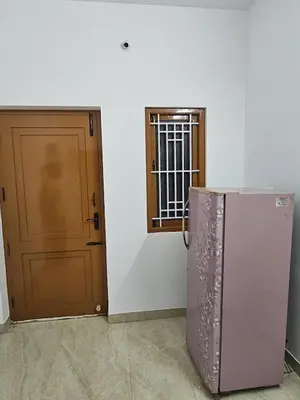 a refrigerator next to a door and a window at Home in Pollachi in Pollāchi