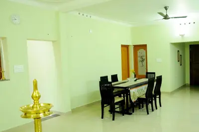a dining room with a table and chairs at SHANKARAM Homestay in Kodanad