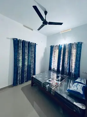 a bedroom with a bed with a ceiling fan at VYSHNAVI 2BHK AC Apartment in Thanniyam