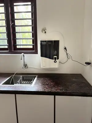 a kitchen counter with a sink and a microwave at Nilavu Homes Retreat in Wayanad