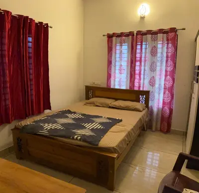 a bed in a room with red curtains at Nilavu Homes Retreat in Wayanad