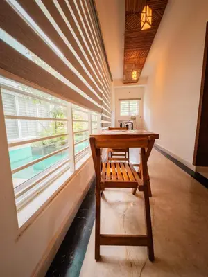 a wooden desk in a room with a window at Akshaya Homestay in Trichūr