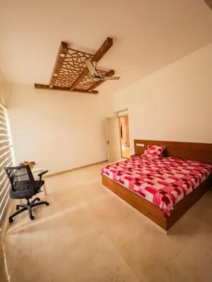 a bedroom with a bed and a chair in it at Akshaya Homestay in Trichūr