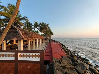 a resort on the beach with palm trees and the ocean at 36 Palms Boutique Retreat in Cherai Beach