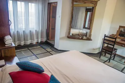 a bedroom with a bed and a mirror and a chair at 36 Palms Boutique Retreat in Cherai Beach