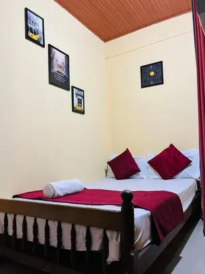 a bedroom with a bed with red pillows at Coorgkushihomestay in Madikeri