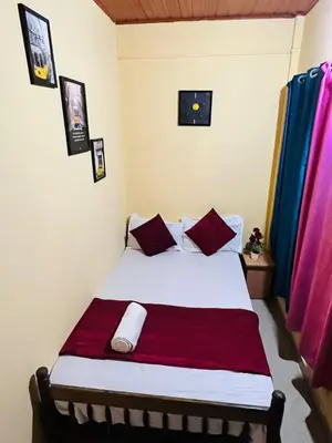 a bedroom with a bed with red and white sheets at Coorgkushihomestay in Madikeri
