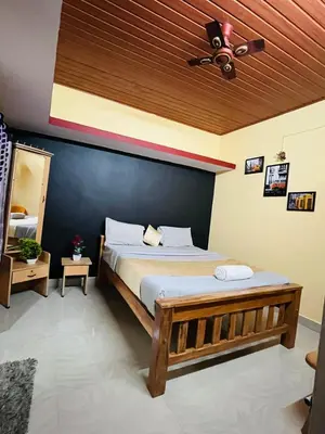 a bedroom with a large bed with a blue wall at Coorgkushihomestay in Madikeri