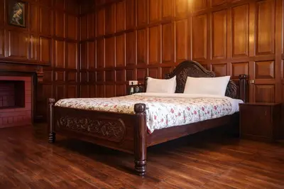a bedroom with a bed with wooden walls and a fireplace at Mount View Heritage by Z Vacations in Ooty