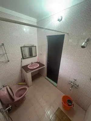 a bathroom with a pink toilet and a sink at GK residency in Kozhikode