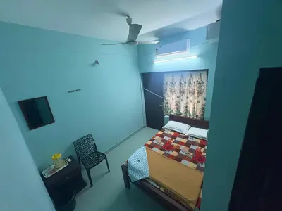 a small bedroom with a bed and a chair at GK residency in Kozhikode