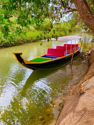 a boat with colorful seats on a river at Kakkakuni heritage in Kozhikode