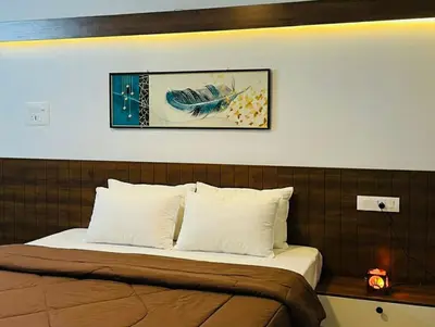 a bedroom with a bed with a picture on the wall at Bison Trails Valley View Kothagiri Ooty Tamilnadu in Kotagiri