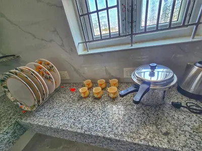 a kitchen counter with a sink and cups on it at Eachanari Karpaga Rathinam Residency By Shivalaya Stays in Coimbatore