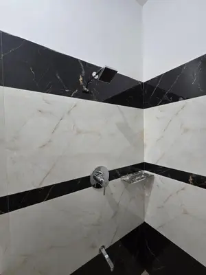 a bathroom with a black and white marble shower at Eachanari Karpaga Rathinam Residency By Shivalaya Stays in Coimbatore