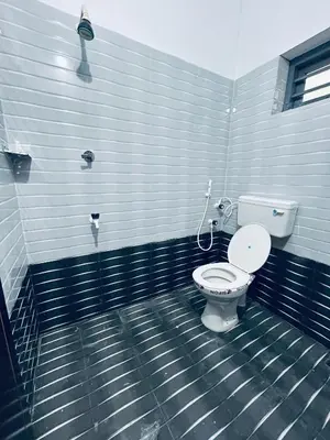 a bathroom with a white toilet in a room at Vyshnavi 2 BHK AC Apartment in Thanniyam