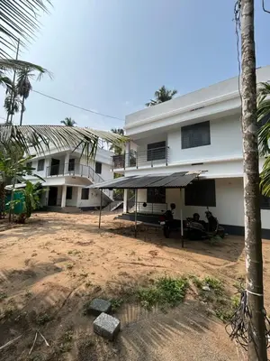 a building with people sitting outside of it at Vyshnavi 2 BHK AC Apartment in Thanniyam
