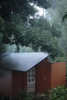 a red and white building with a black roof at Hill wood nature touch resort in Pinangode