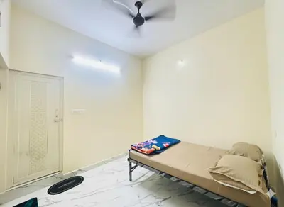 a bedroom with a bed and a ceiling fan at Forum Stay in Mysore