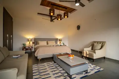 a bedroom with a bed and a living room at Safari Farms Resorts and Leisure in Kandivalli