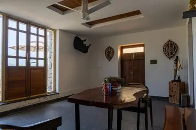 a living room with a wooden table and a window at Safari Farms Resorts and Leisure in Kandivalli