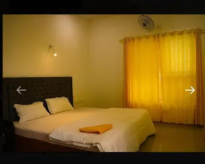 a bedroom with a bed with a orange towel on it at The NEST VILLAS in Athirappilly