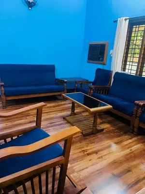 a blue room with couches and a table and chairs at Chirakkal Heritage Luxury Homestay in Manjeri