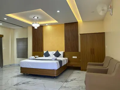a bedroom with a bed and a chair in it at FORTUNE BANASURA Resort in Kalpetta