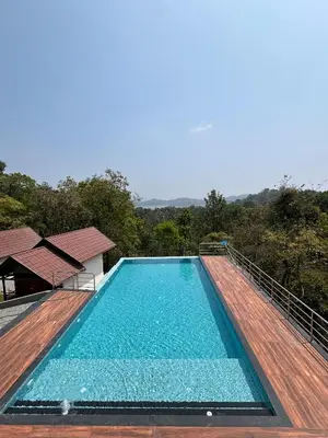 a swimming pool on top of a wooden deck at FORTUNE BANASURA Resort in Kalpetta