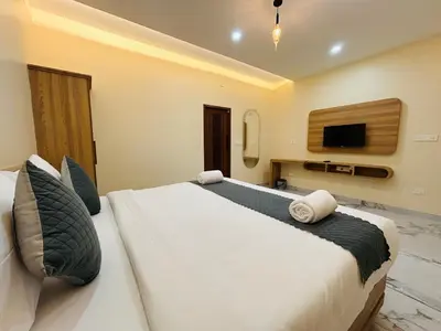 a bedroom with a large bed and a tv at FORTUNE BANASURA Resort in Kalpetta