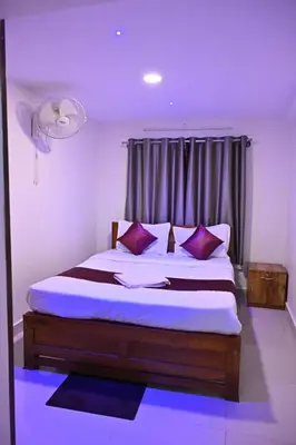 a bedroom with a large bed with purple pillows at Radisson in Madikeri