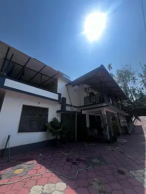a white house with the sun in the sky at Ashique holiday home in Padinjarathara