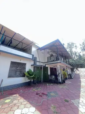 a house with a red brick yard in front of it at Ashique holiday home in Padinjarathara