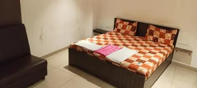 a bedroom with a bed with a checkered blanket at Hotel AB Merridien in Coimbatore