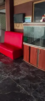 a red couch in a room with a fish tank at Hotel AB Merridien in Coimbatore